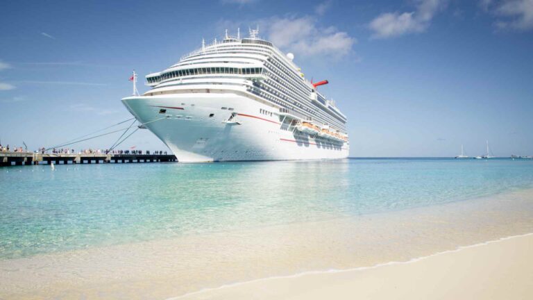 Cruise ship anchored just offshore from a white sand beach in Belize