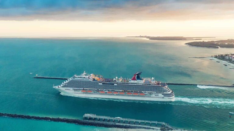 Carnival cruise ship sailing past low islands and turquoise water in Florida