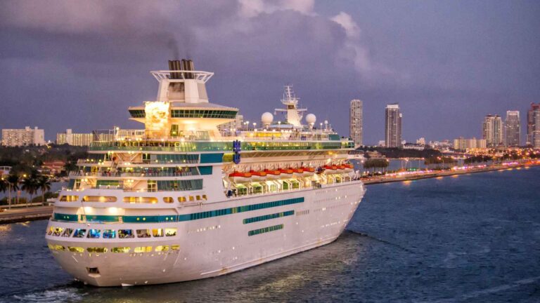 Cruise ship departing PortMiami with the Miami skyline glowing at dusk