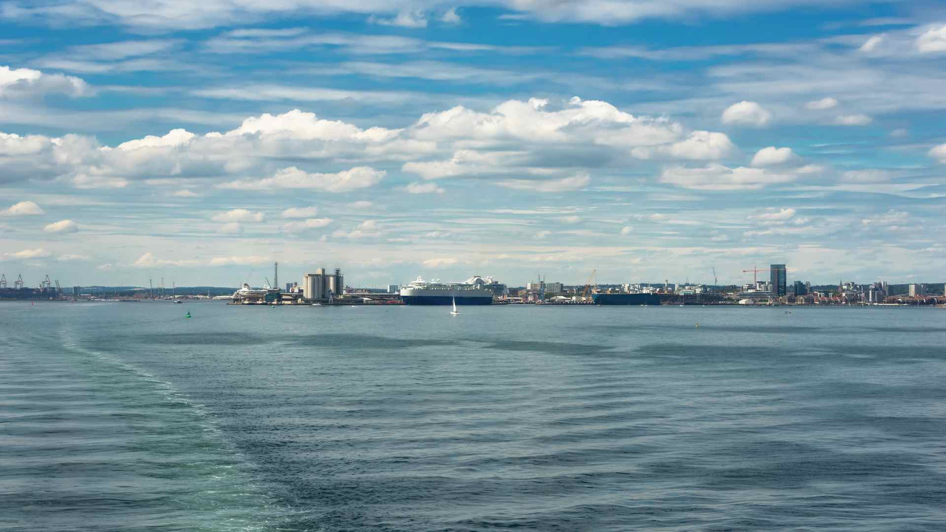 Southampton Water and distant industrial harbor viewed beneath a cloudy sky