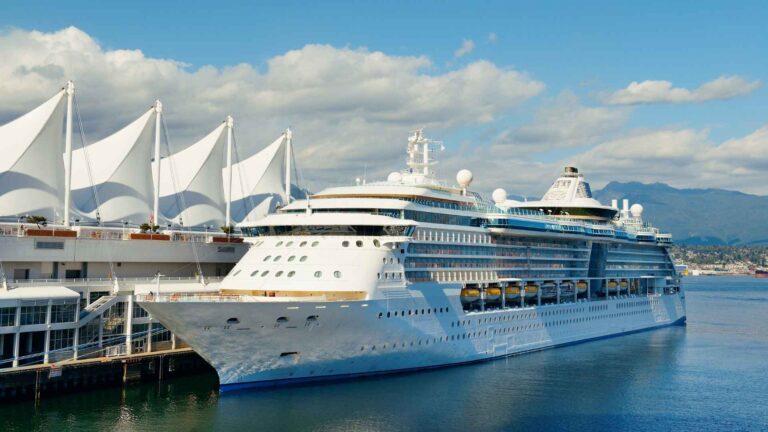 Cruise ship docked beside the white sails of Canada Place