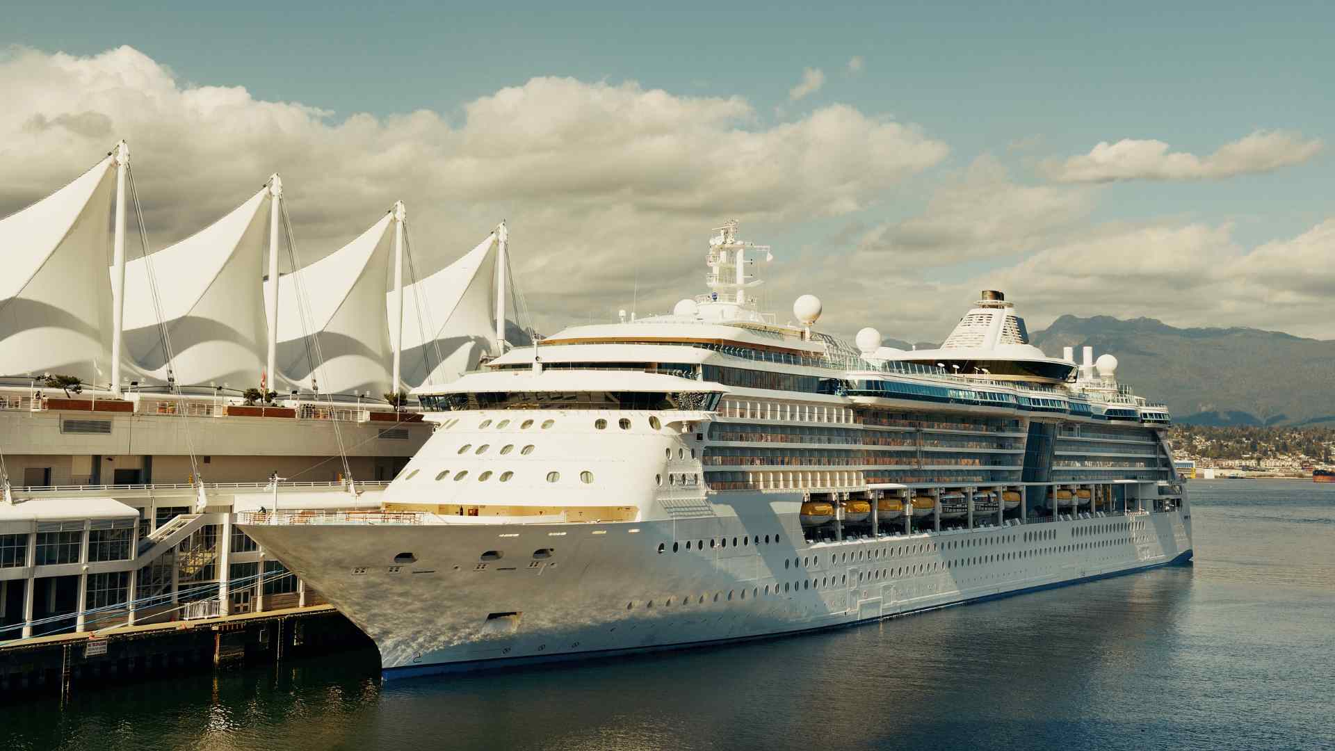 Cruise ship alongside Canada Place with mountains beyond Vancouver harbor
