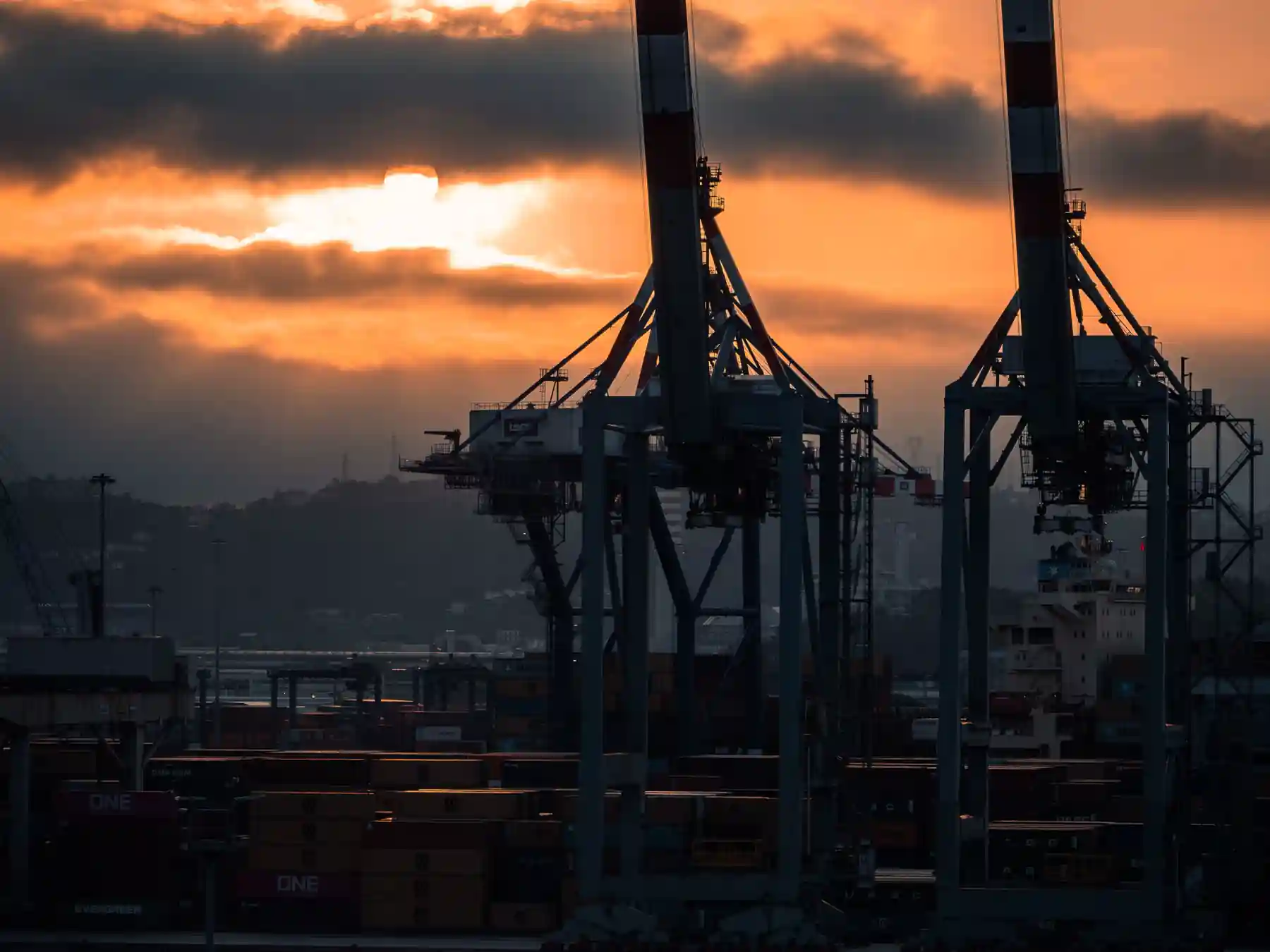 Sunset behind container cranes at the commercial port of La Spezia.