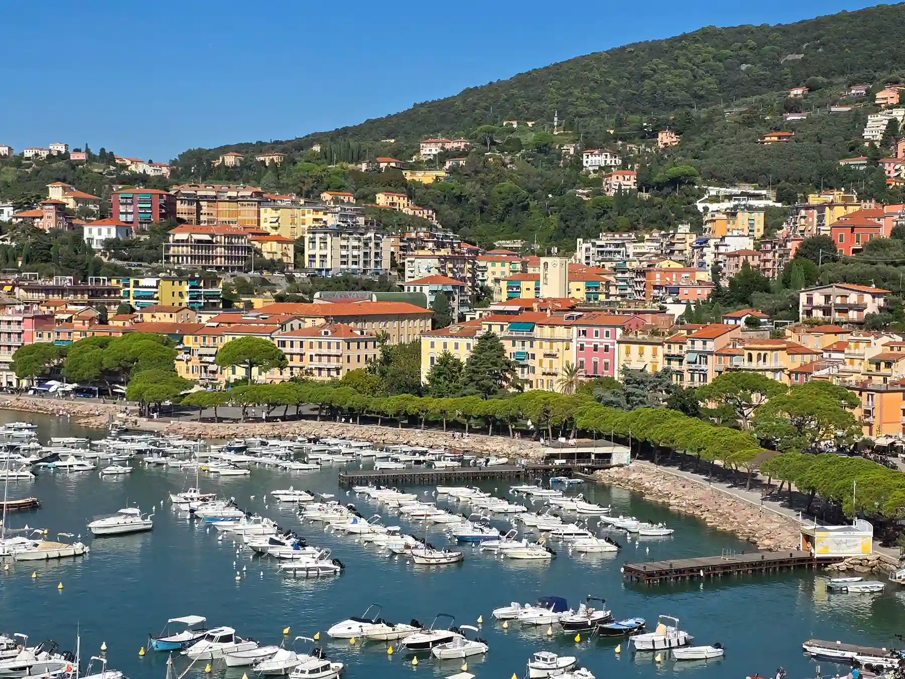 Colorful buildings and small boats along the waterfront marina in La Spezia.