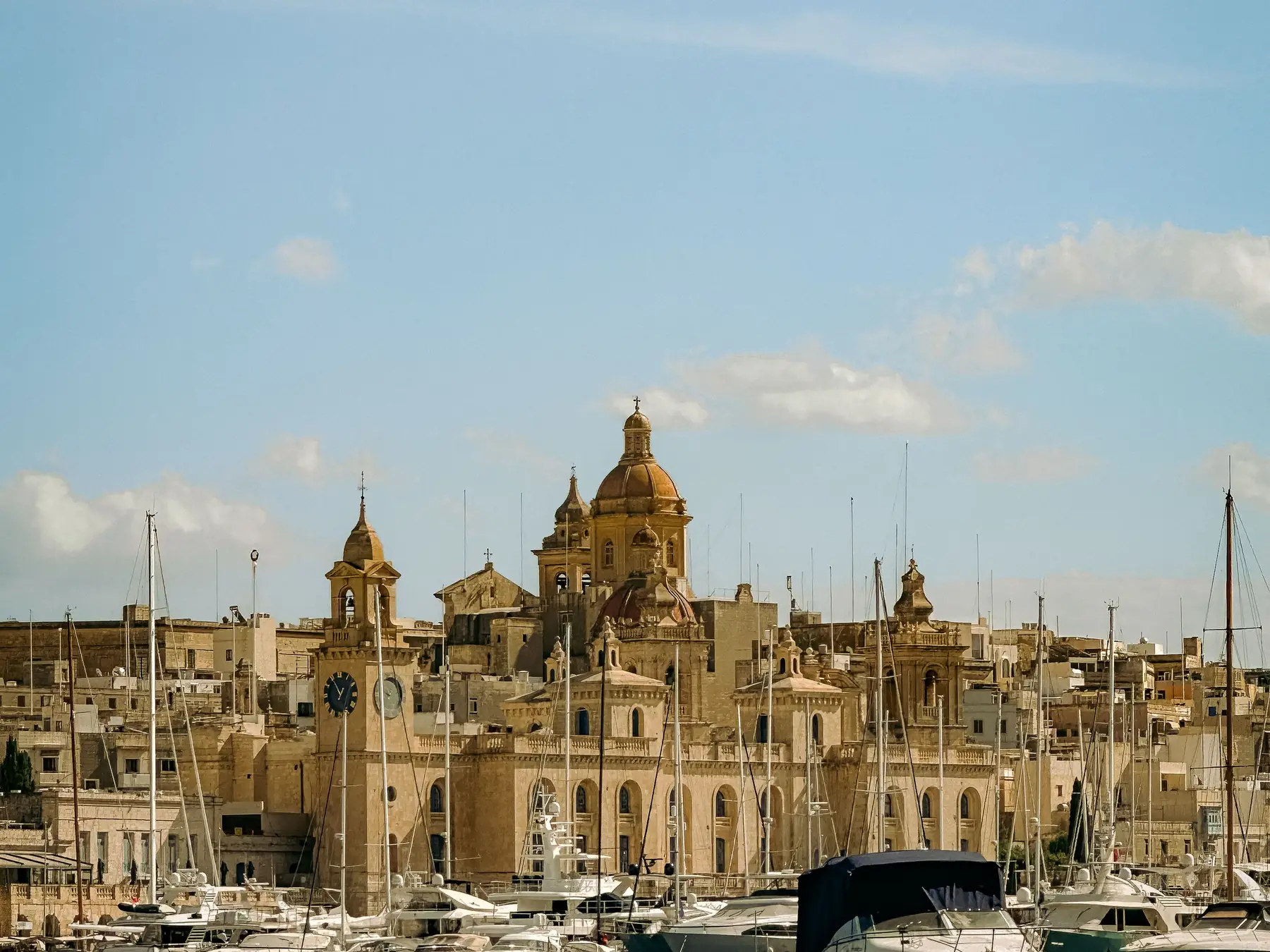 Historic church domes and sailboats along the Valletta waterfront.