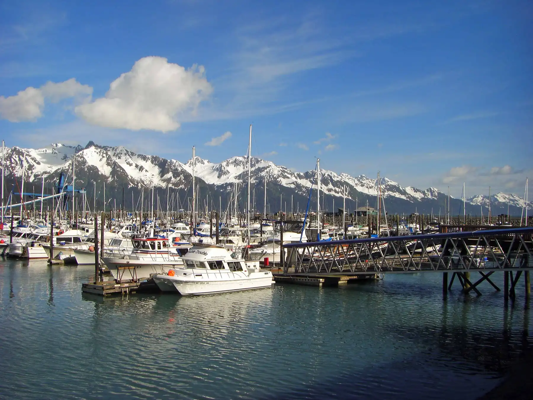 Small boats moored in Seward marina with mountains rising behind the harbor.