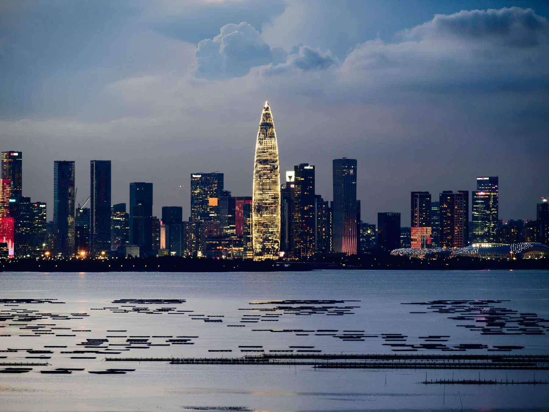 Shenzhen’s illuminated skyline reflected across the waterfront at night.