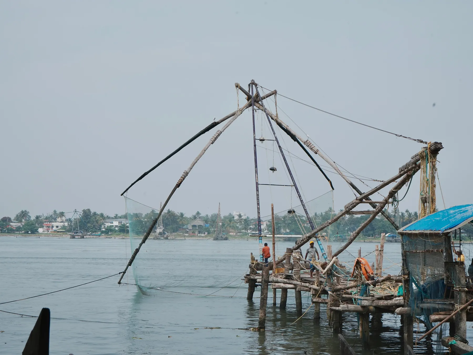Fishermen working beside traditional Chinese fishing nets in Kochi