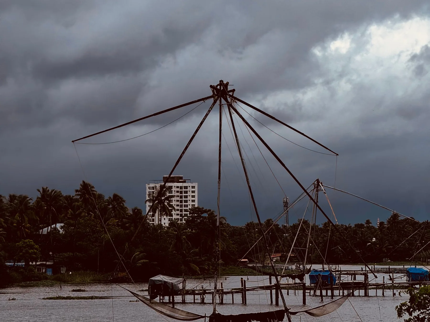 Chinese fishing nets silhouetted over Kochi waterfront at twilight
