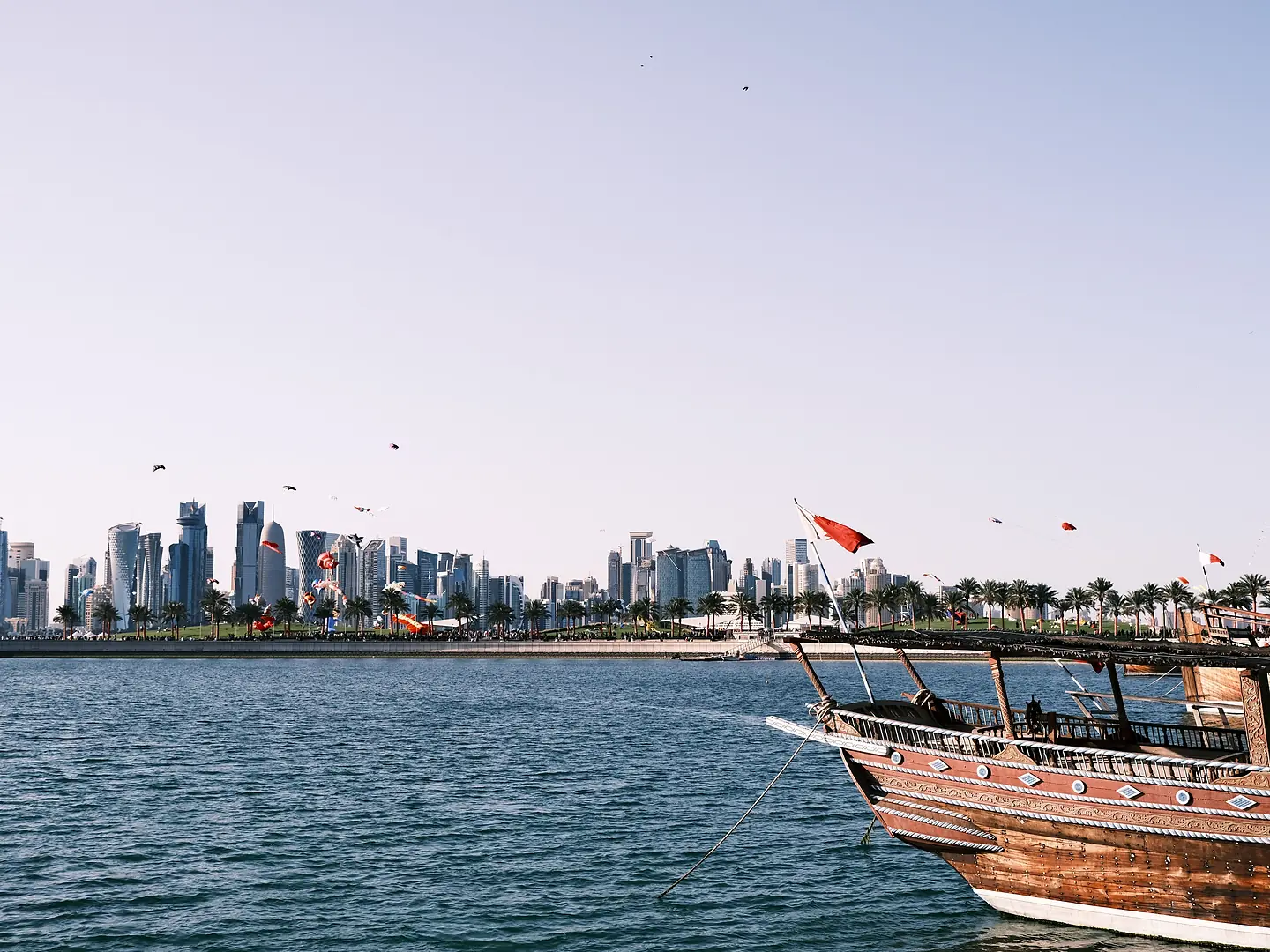 Traditional dhow sailing across Doha Bay with the skyline beyond