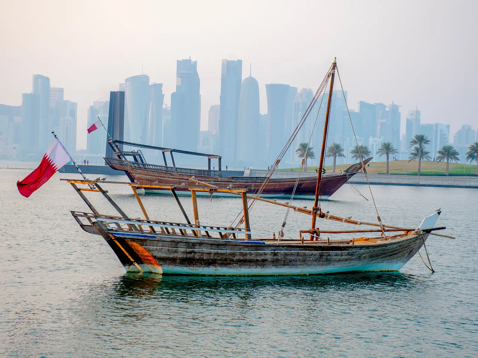 Traditional dhow boats in Doha Bay with the city skyline behind