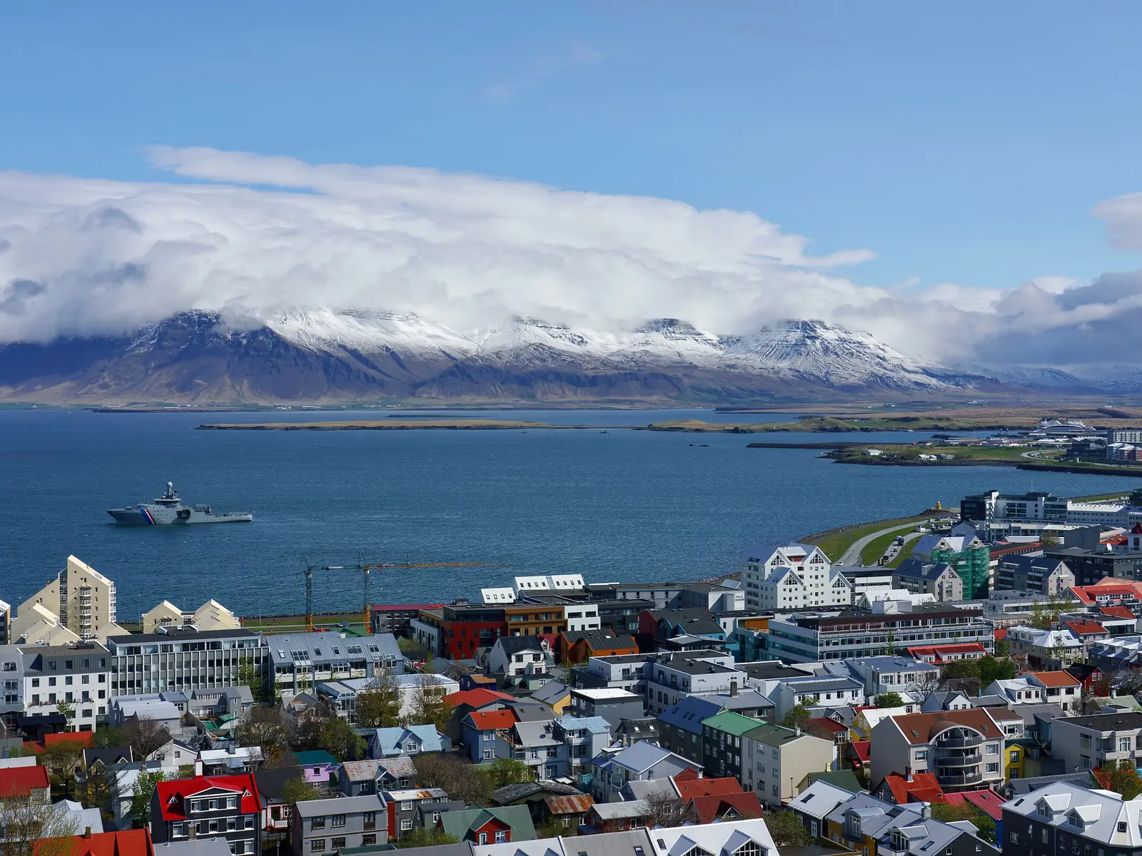 Reykjavík skyline with Hallgrímskirkja, the sea, and distant mountains