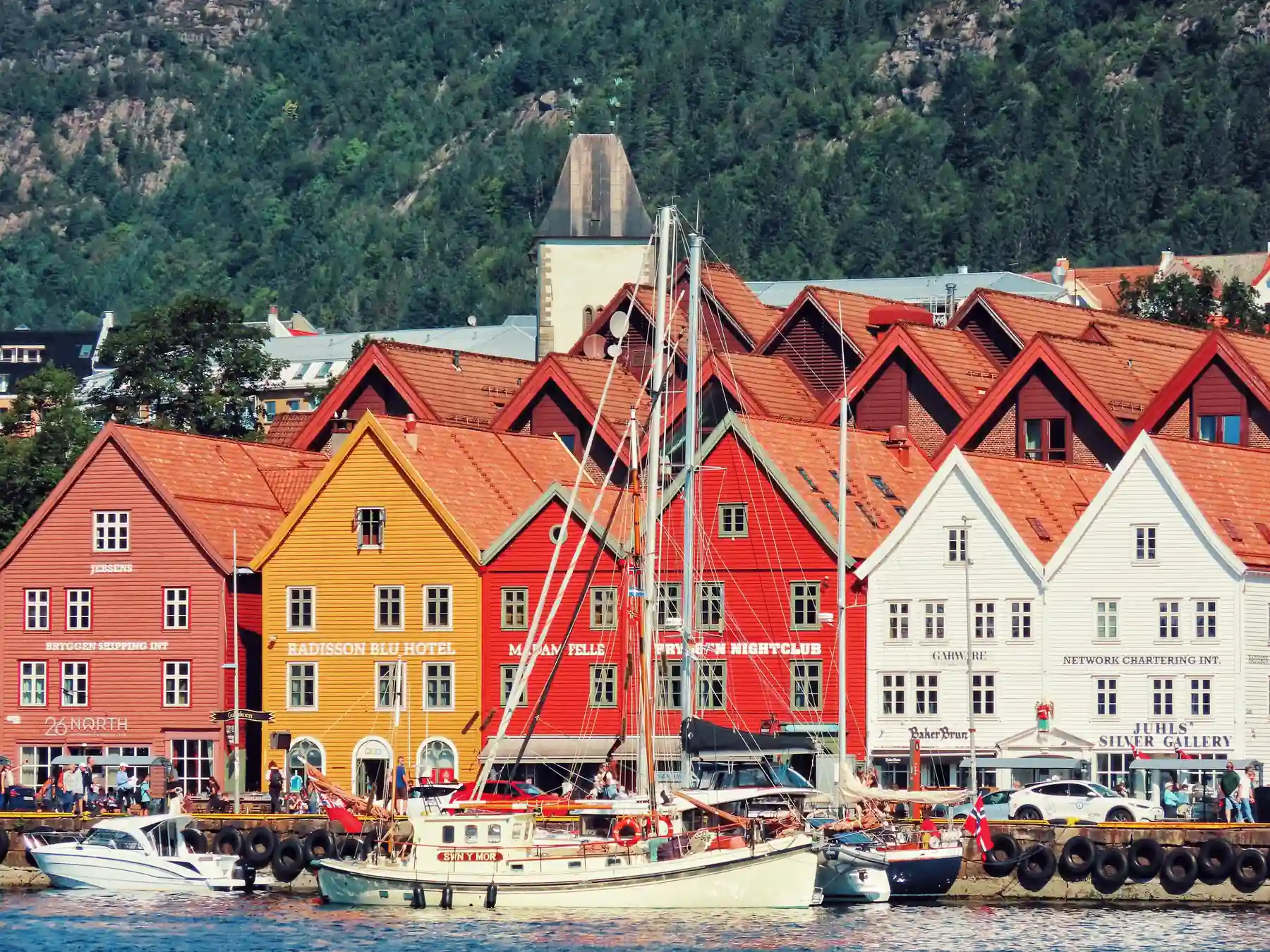 Colorful historic Bryggen buildings and boats along Bergen's waterfront.