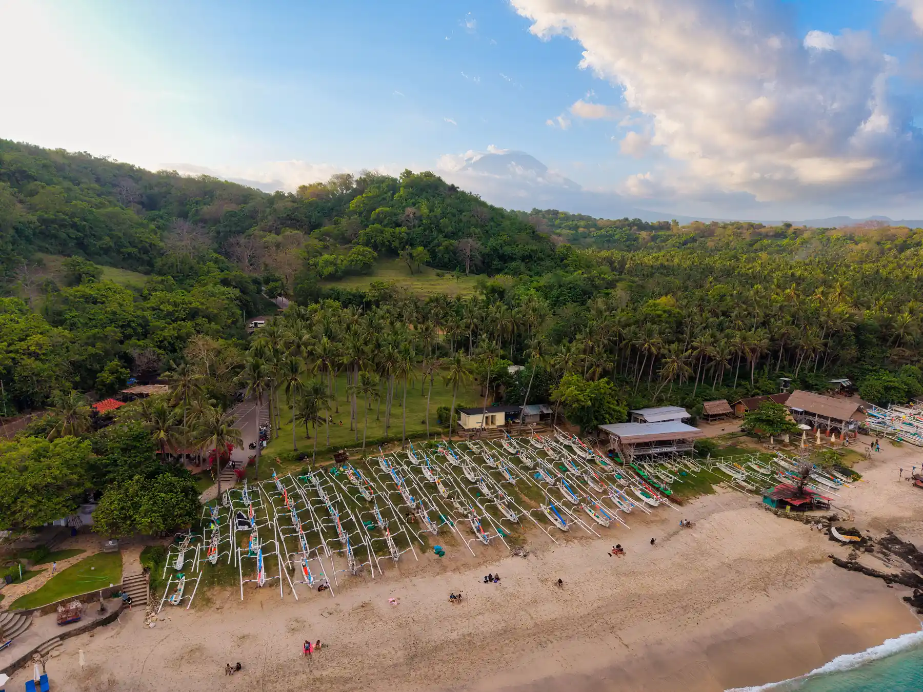 Aerial view of traditional fishing boats on a tropical Bali beach.