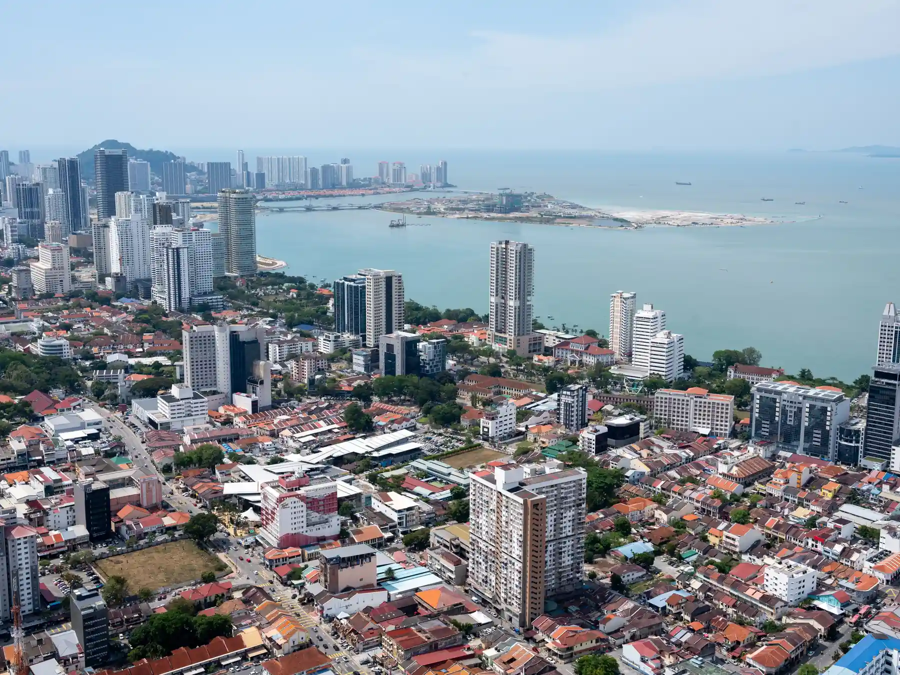 Aerial view of Penang's urban skyline and coastal waterfront.