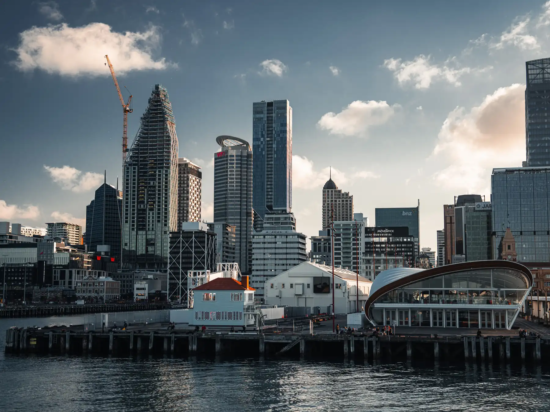 Auckland's modern skyline reflected in the waterfront harbor.