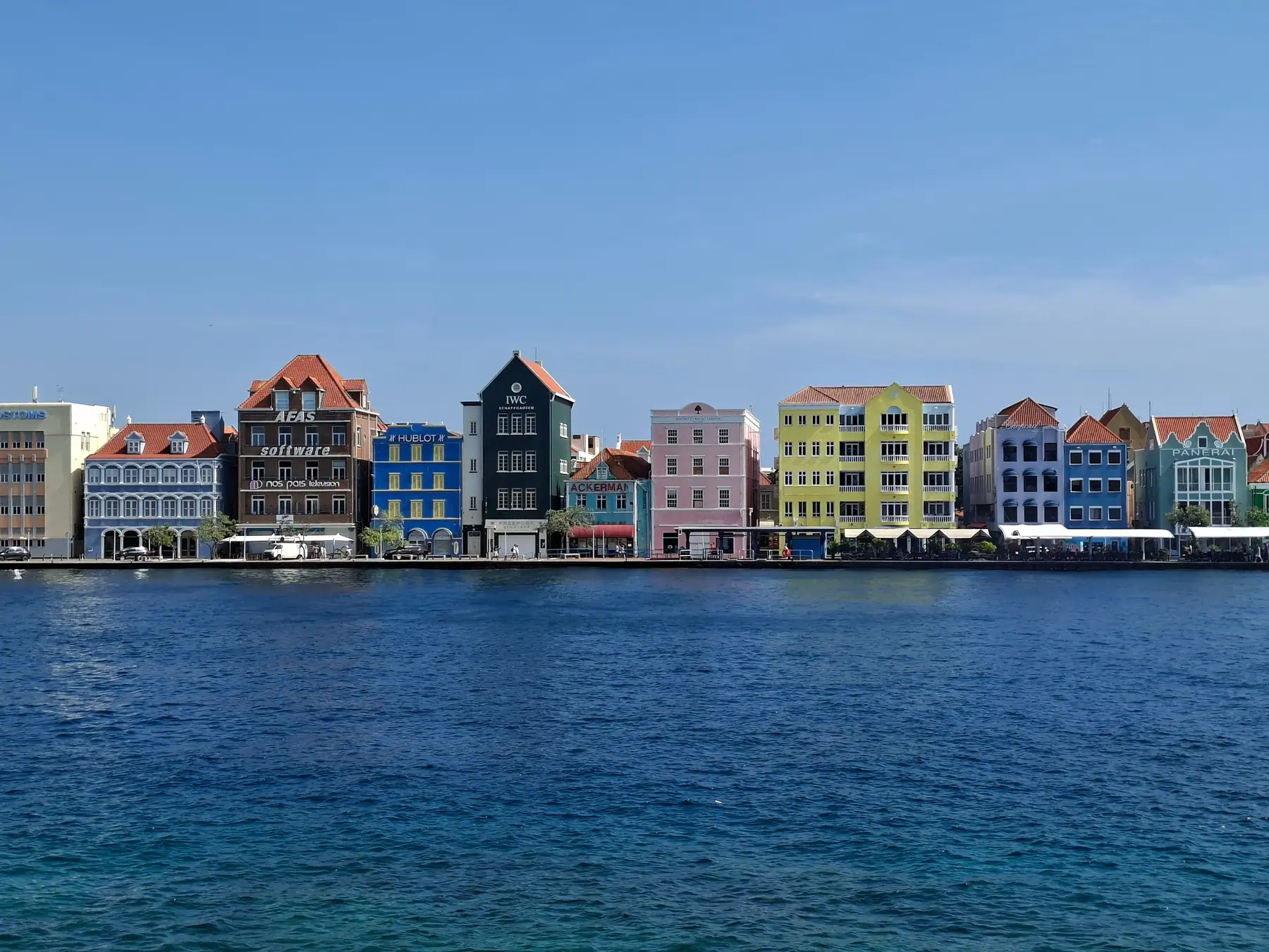 Pastel waterfront buildings near Queen Emma Bridge in Willemstad.