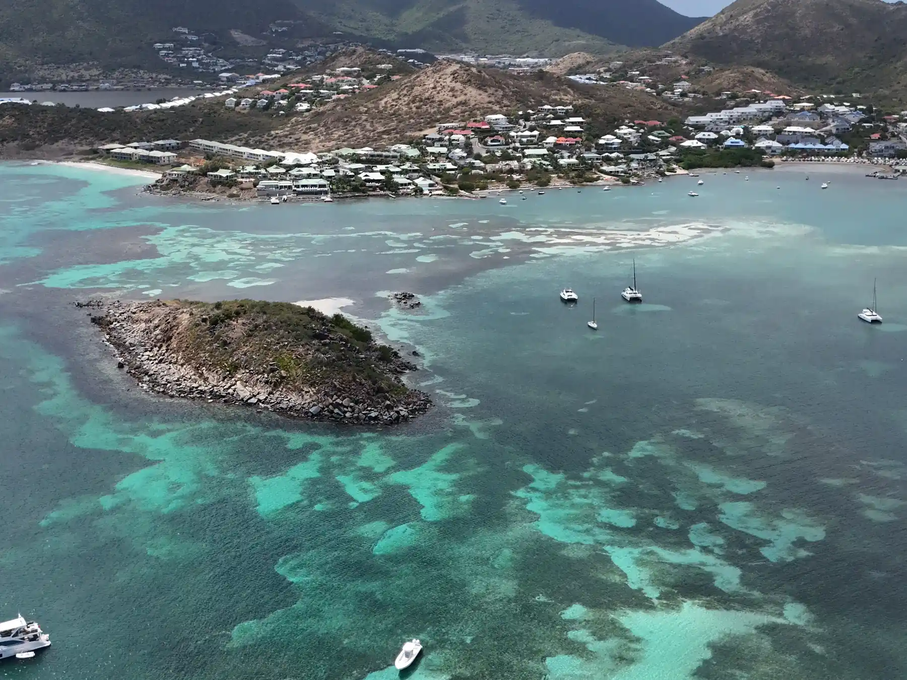 Aerial view of turquoise water, islands, and boats along the Sint Maarten coast.