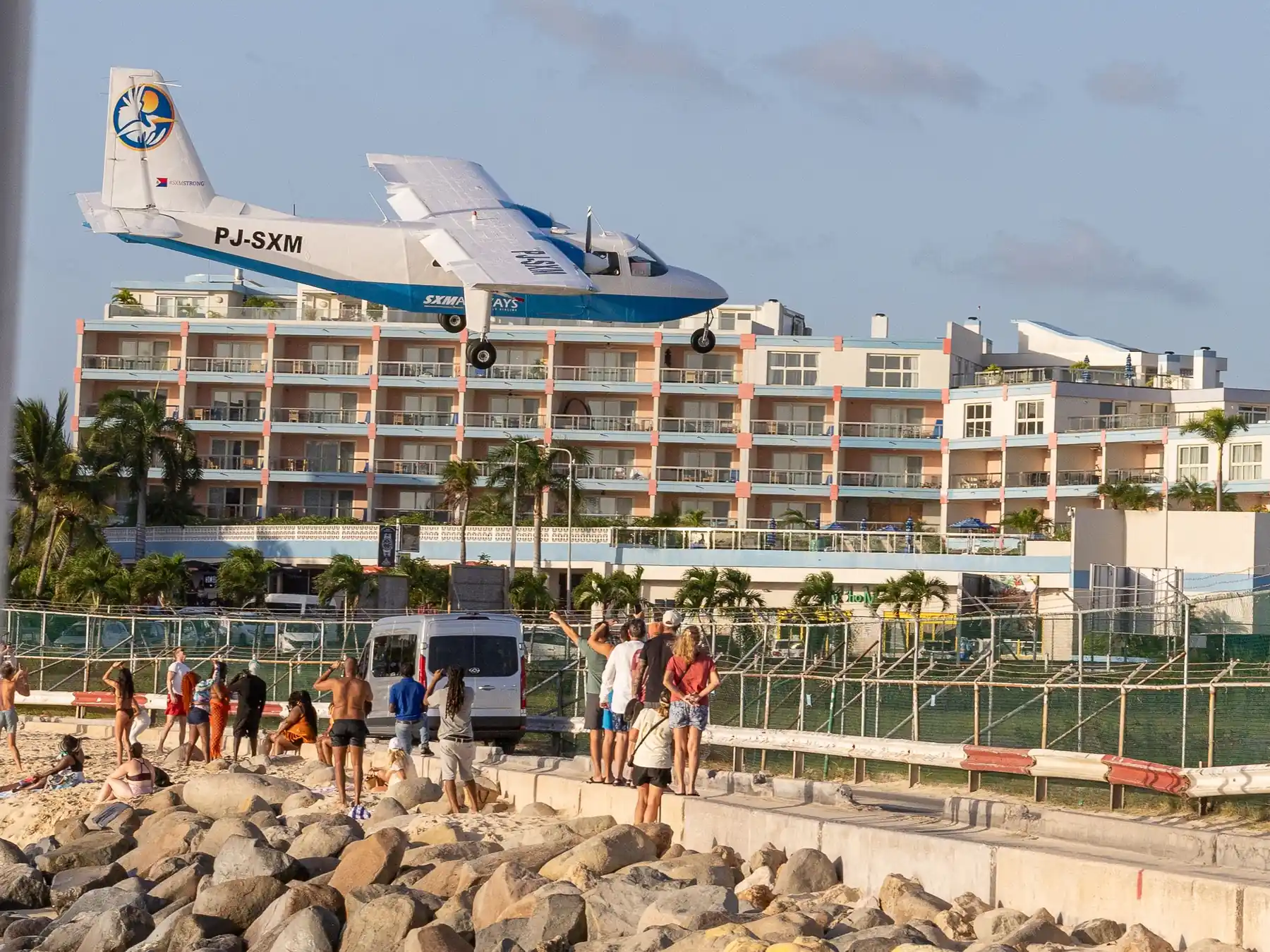 Airplane flying low over beachgoers at Maho Beach in Sint Maarten.