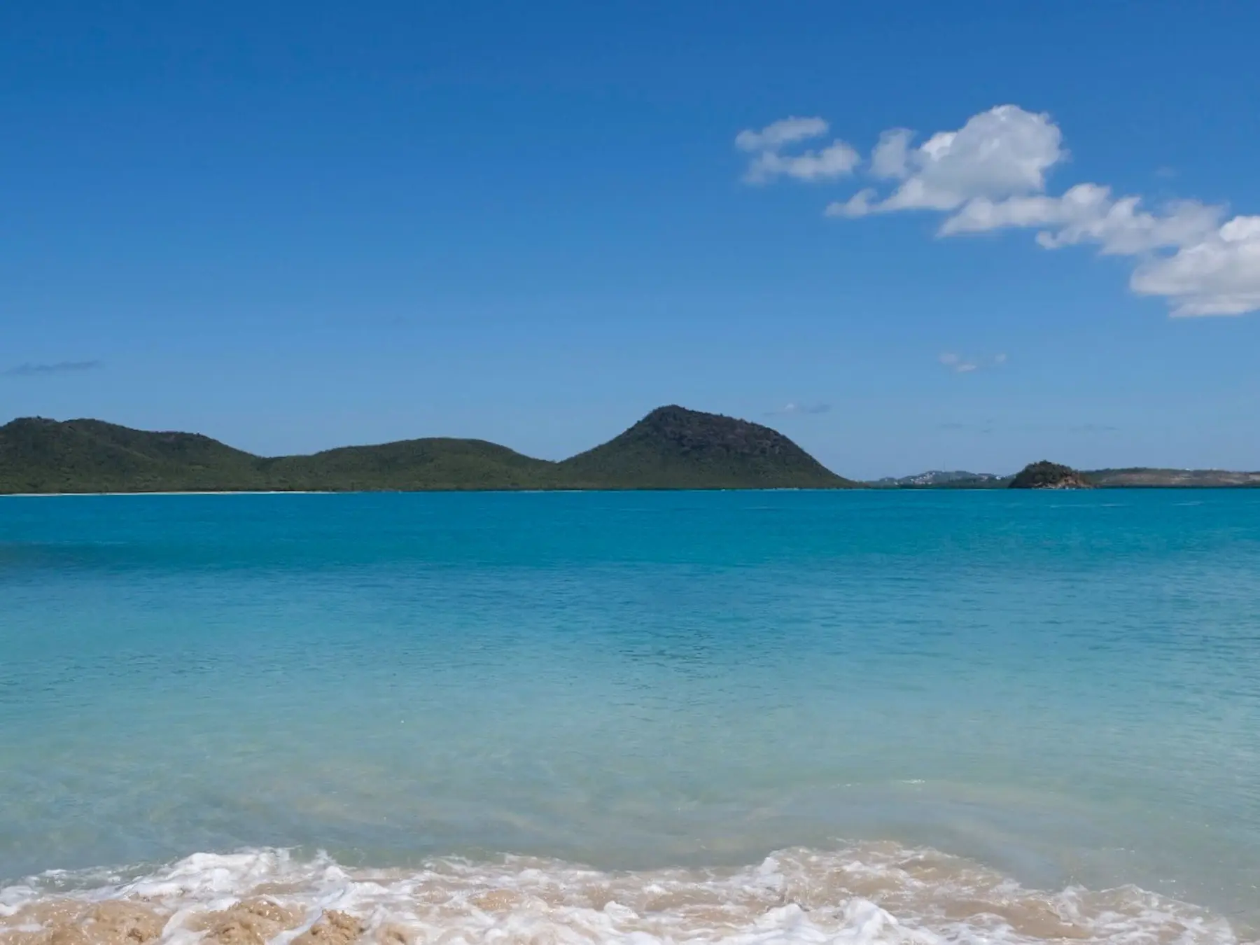 Calm turquoise water and sandy shoreline near St. John's, Antigua.
