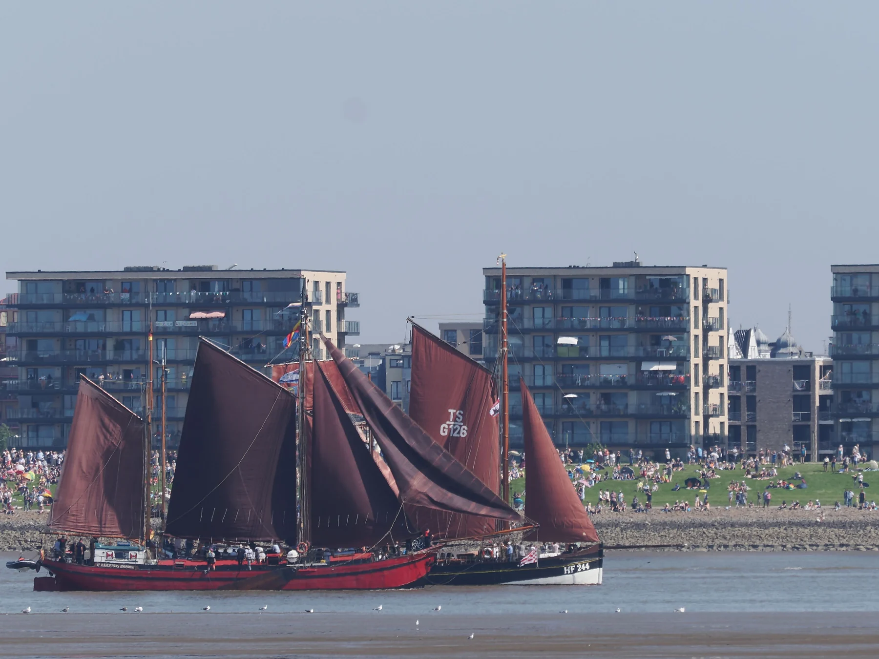 Traditional sailing ship with red sails in Bremerhaven harbor.