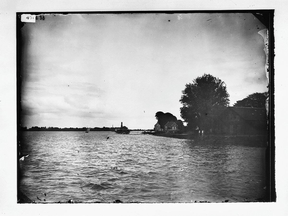 Overzicht, rechts de werf en loods van de roedenfabrikant Pot, op de achtergrond de Sluiswachterswoning en waterschapssluis van het waterschap "De Overwaard - Kinderdijk - 20125336 - RCE, Kinderdijk