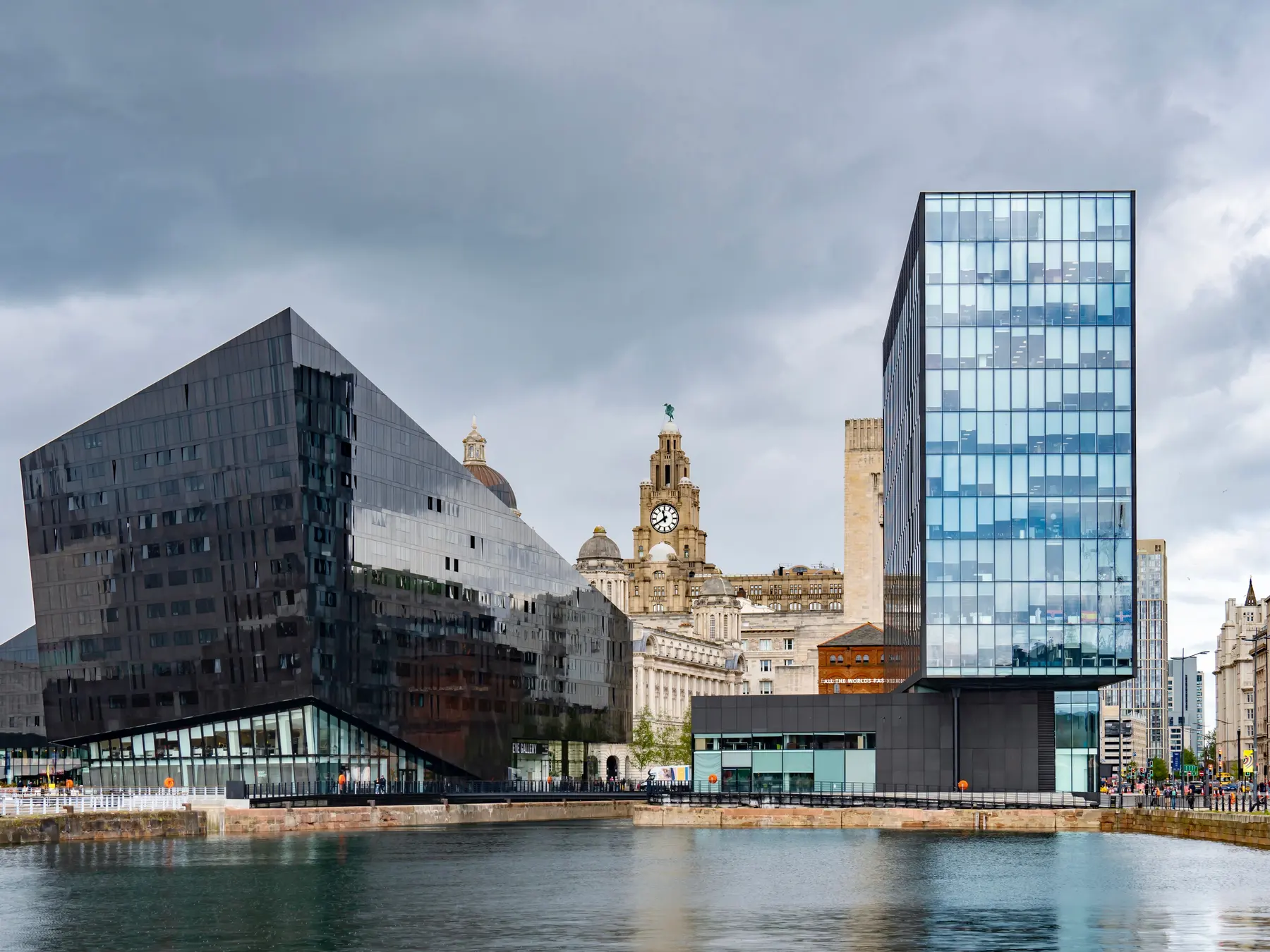 Museum of Liverpool and historic waterfront buildings reflected in the dock water.
