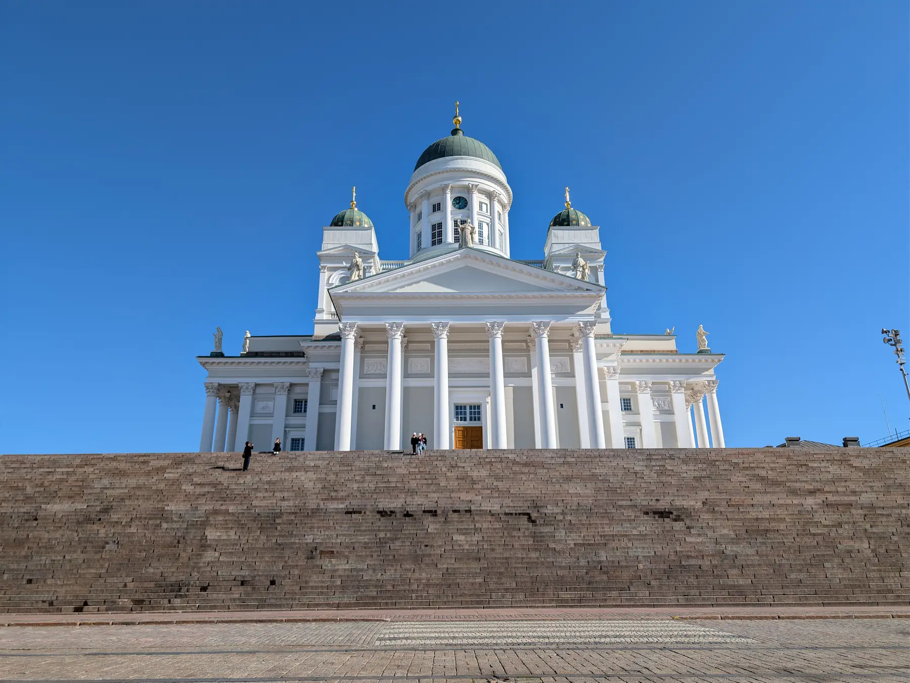 White neoclassical Helsinki Cathedral rising above the broad steps of Senate Square.