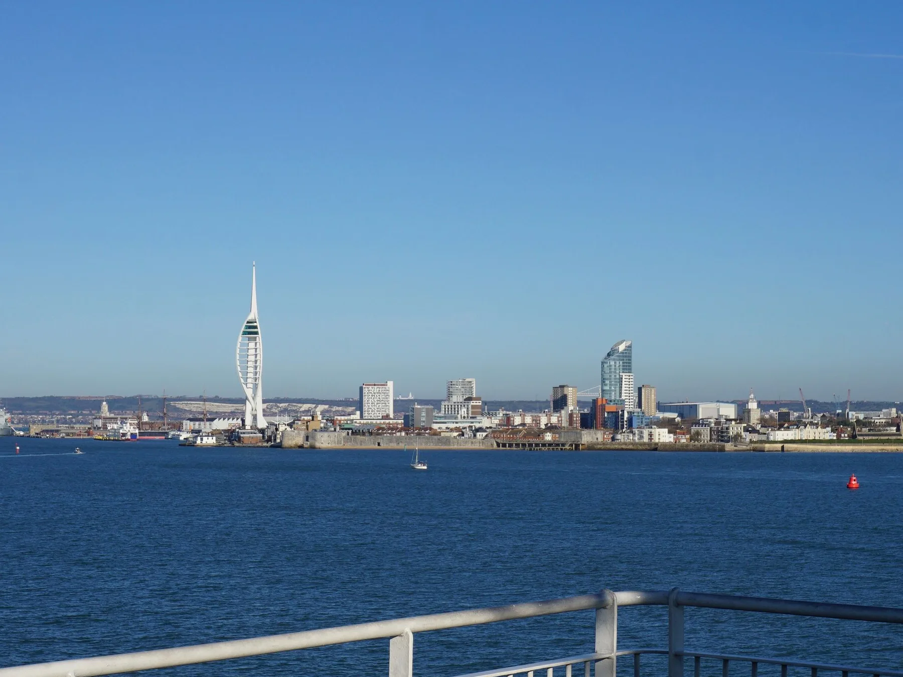 Portsmouth skyline and Spinnaker Tower seen across the harbor from the water.