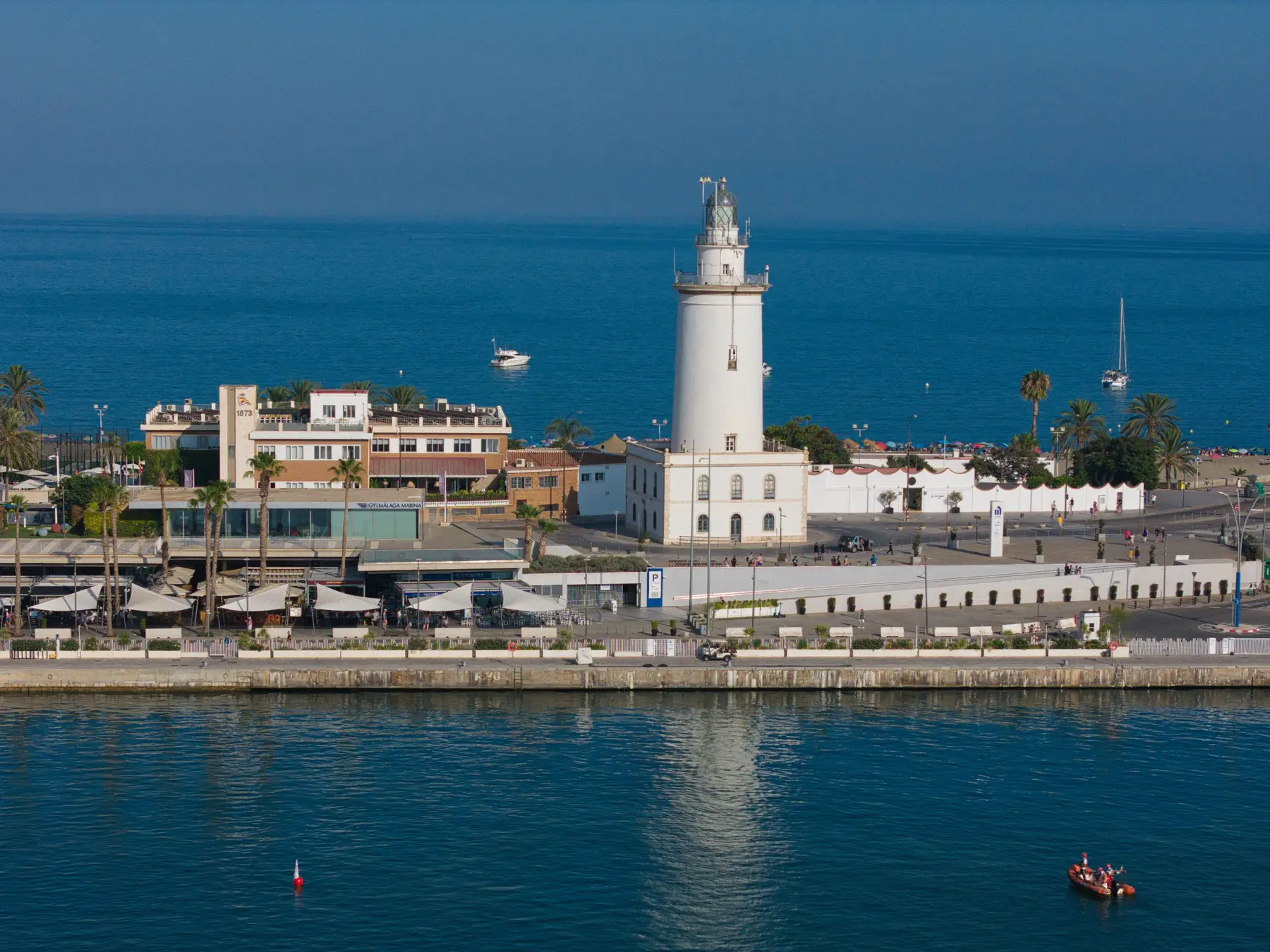 La Farola lighthouse on the Málaga port waterfront beside the Mediterranean Sea.