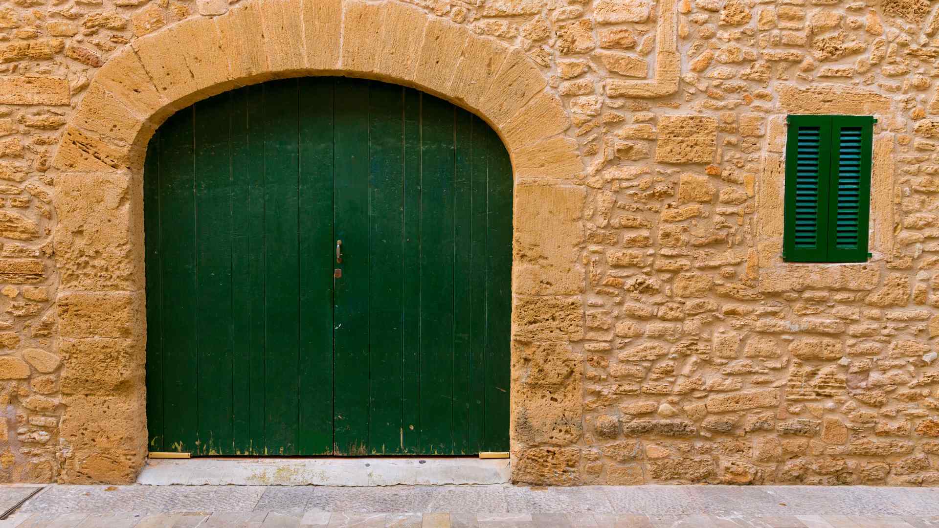 Stone wall with a green wooden door in Alcudia Old Town