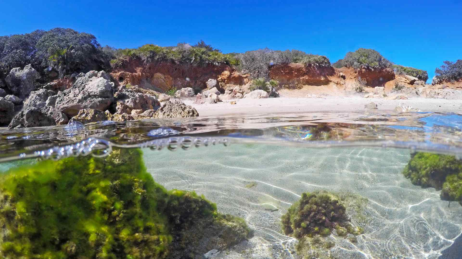 Clear tidal pool among rocks on the Alghero coast