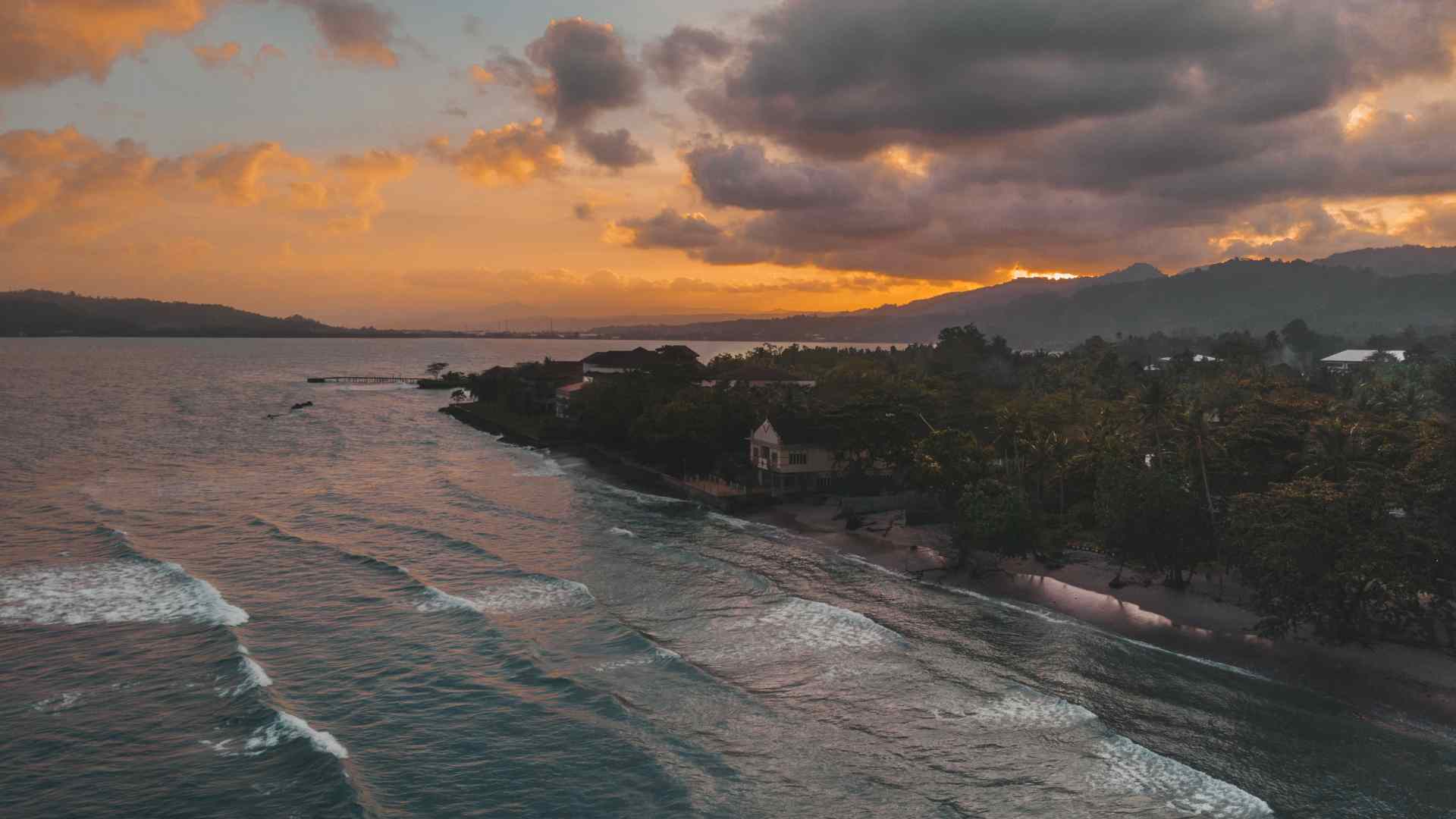 Sunset over a rocky shoreline on Ambon Island