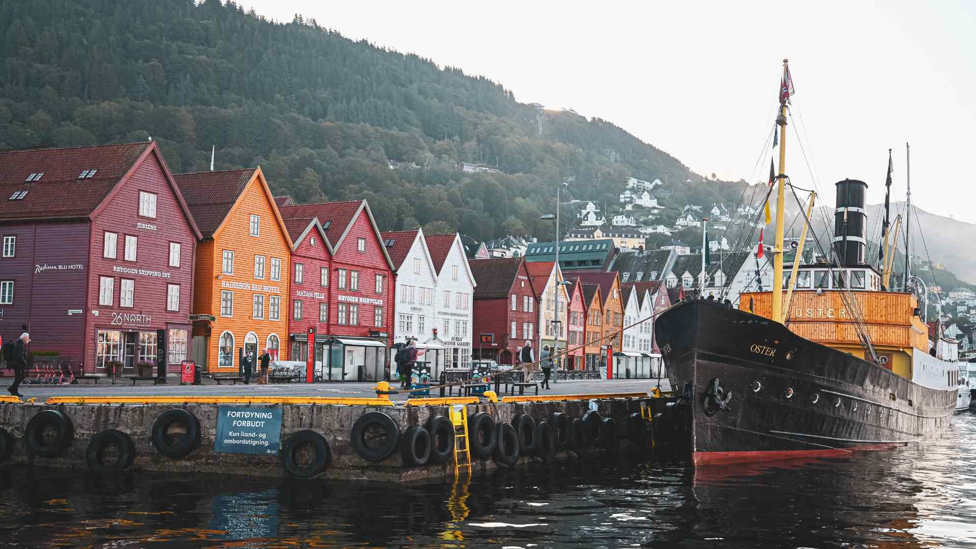Colorful Bryggen warehouses and historic ship in Bergen