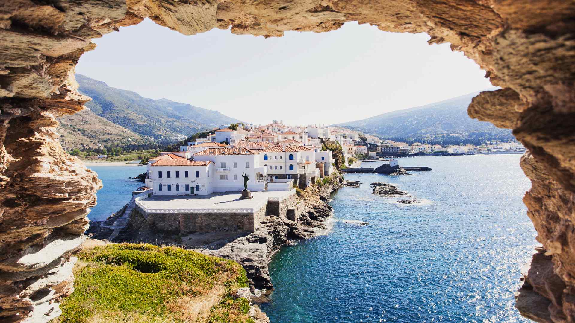 Andros coastal village framed by a rocky cave opening