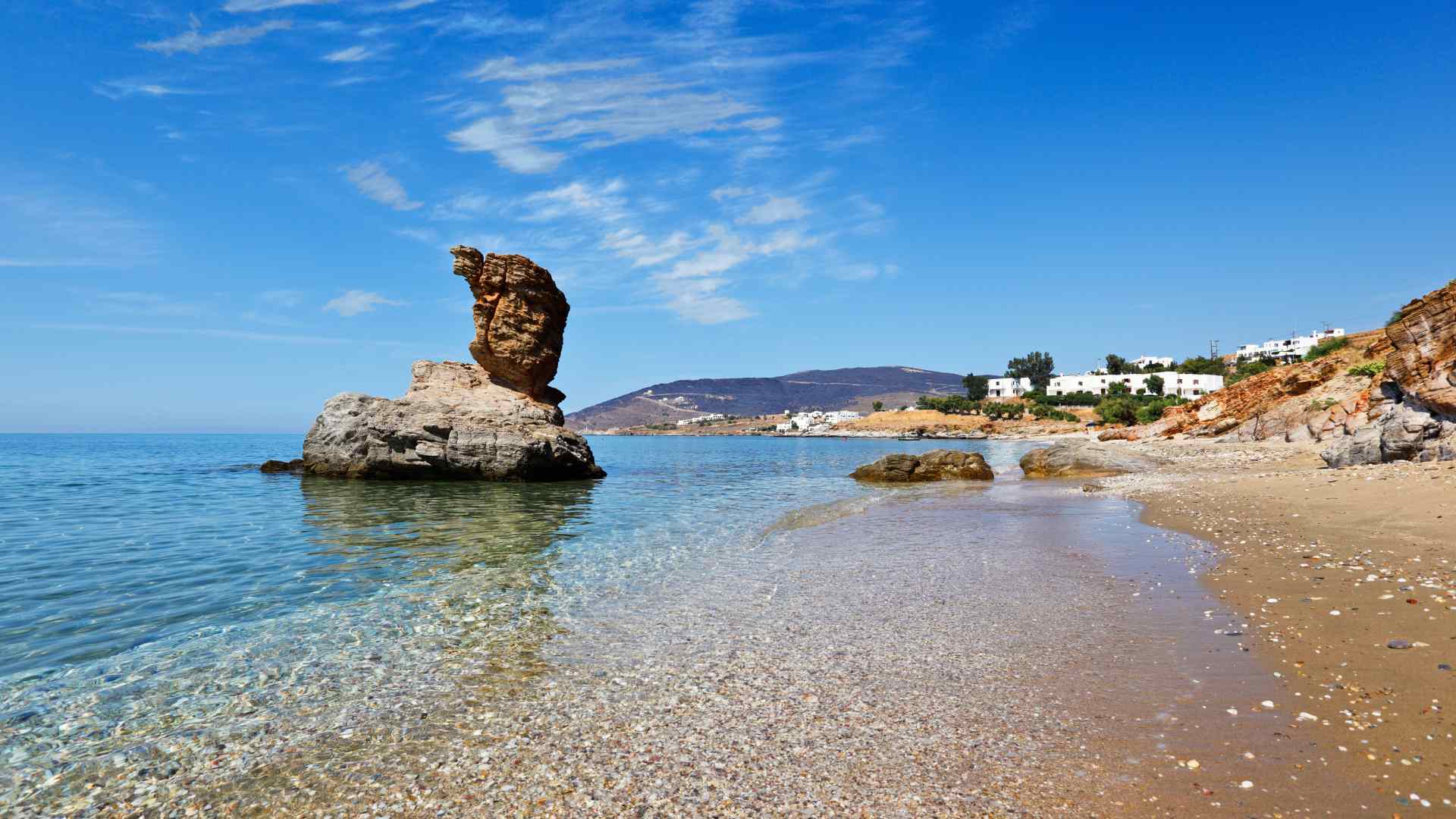 Sea stack rising from a pebble beach on Andros
