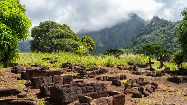 Archaeological ruins beneath tropical mountains on Hiva Oa