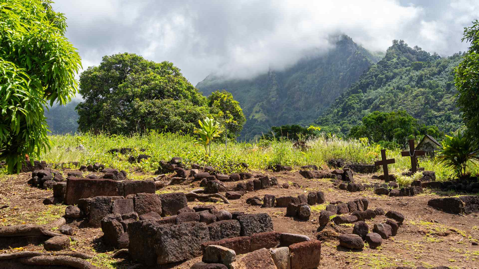 Archaeological ruins beneath tropical mountains on Hiva Oa