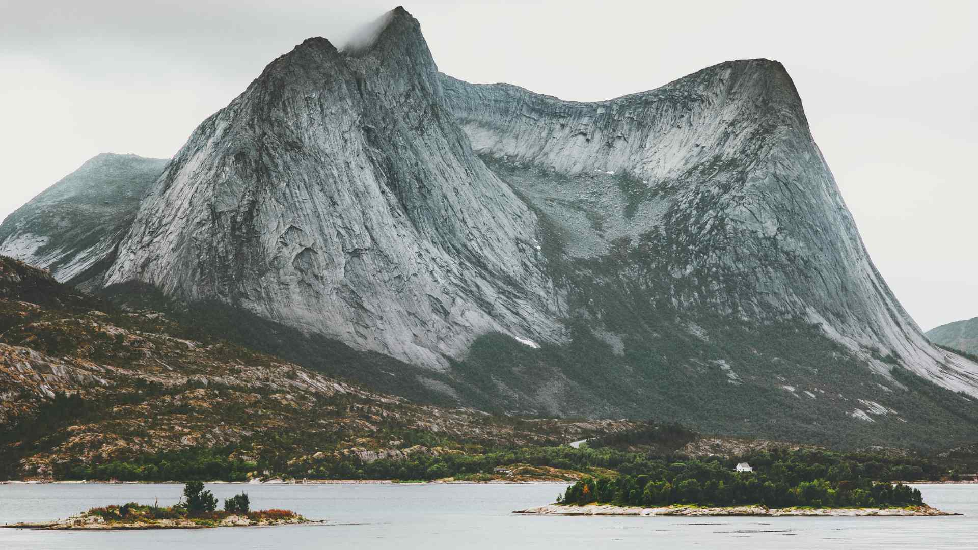 Dramatic granite peak rising above a Norwegian fjord