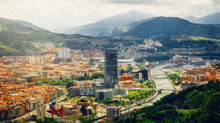 Aerial panorama of Bilbao surrounded by green Basque hills