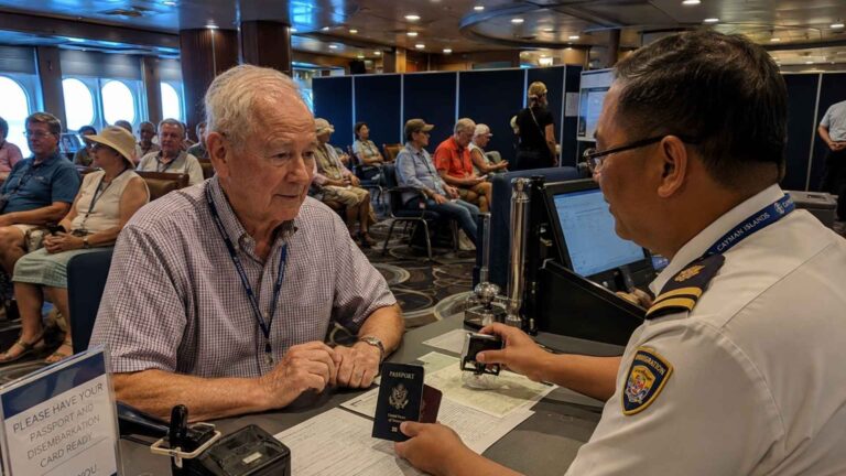 old man having his passport checked on a cruise ship