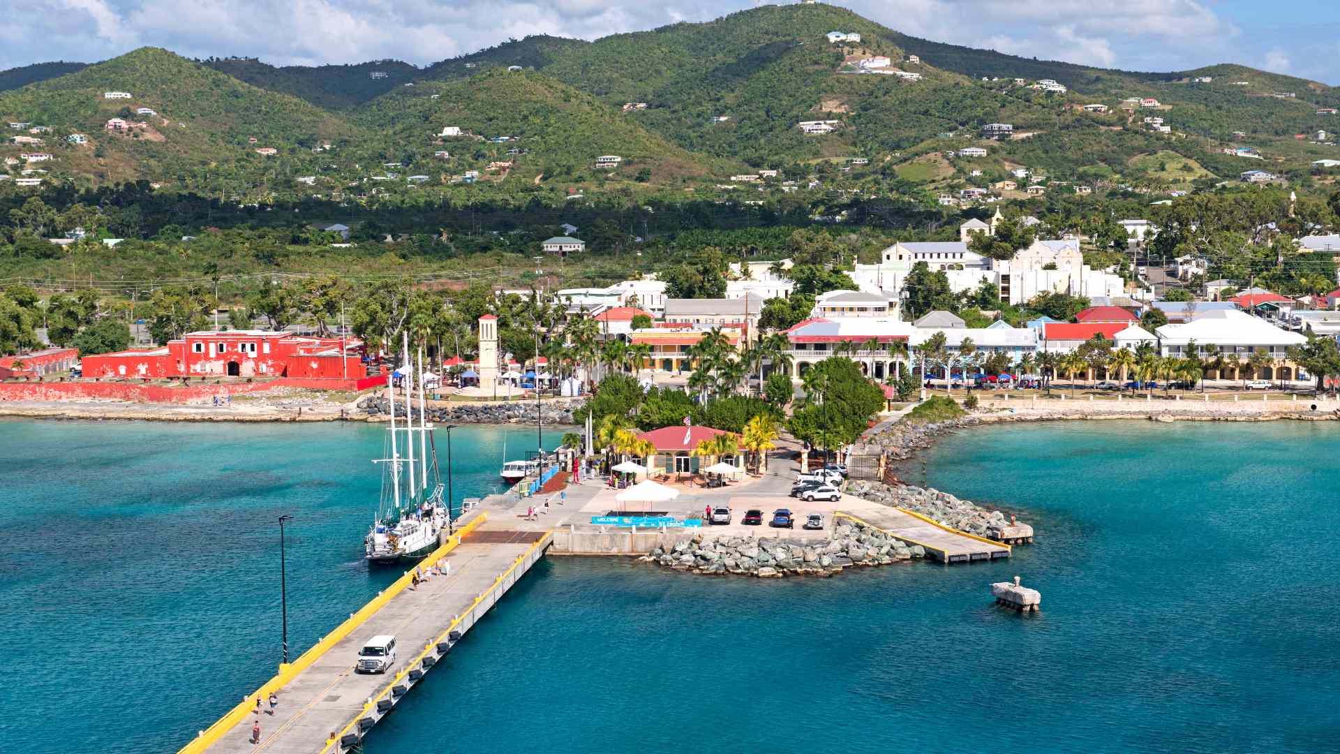 Frederiksted pier and waterfront beneath green Caribbean hills