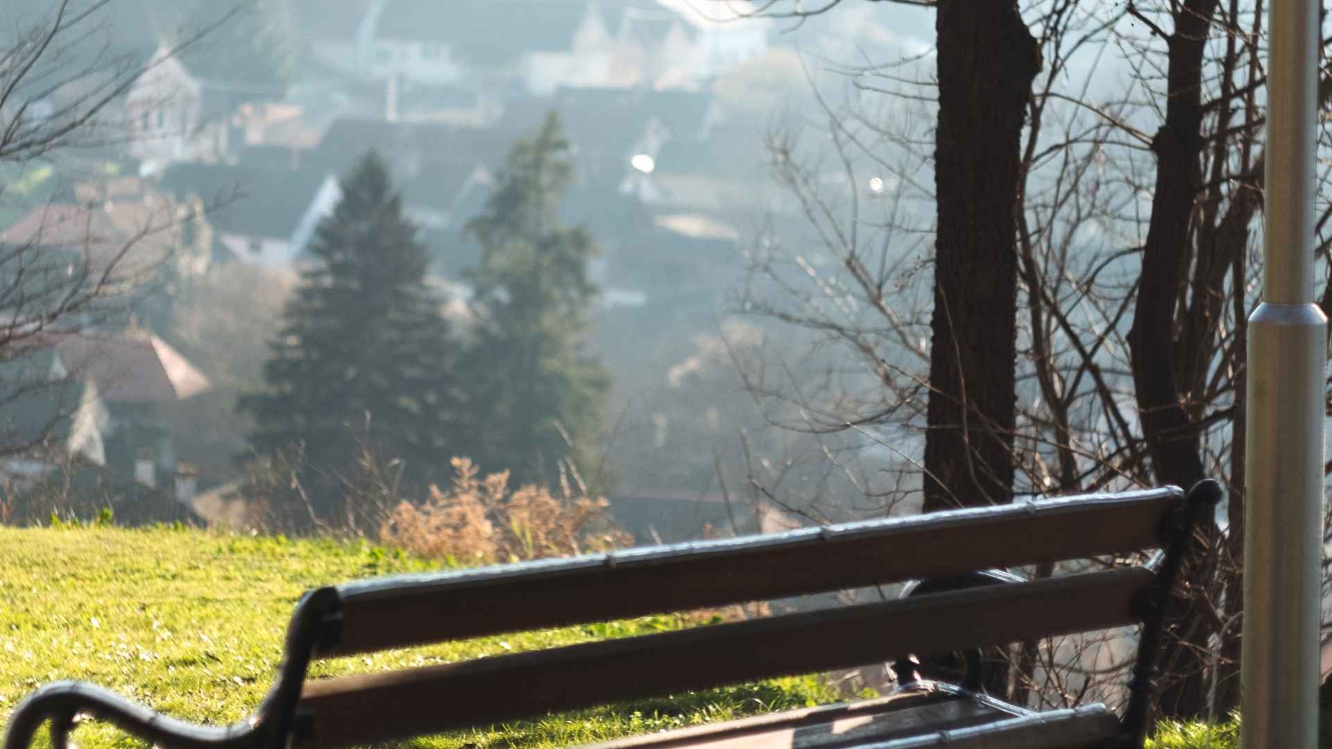 Foggy morning view over a river with a bench in the foreground
