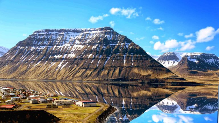 Isafjordur beneath steep mountains reflected in the fjord