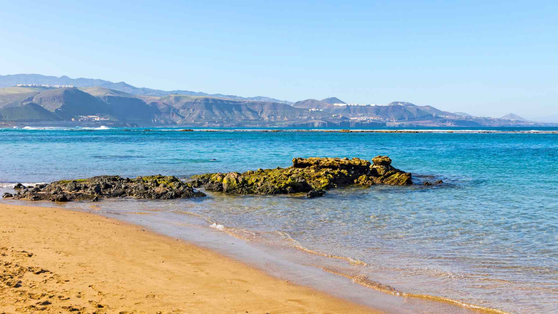 Sandy beach and volcanic shoreline near Las Palmas