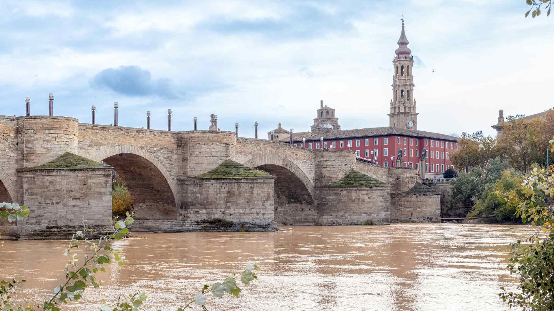 Historic stone bridge and bell tower beside a river