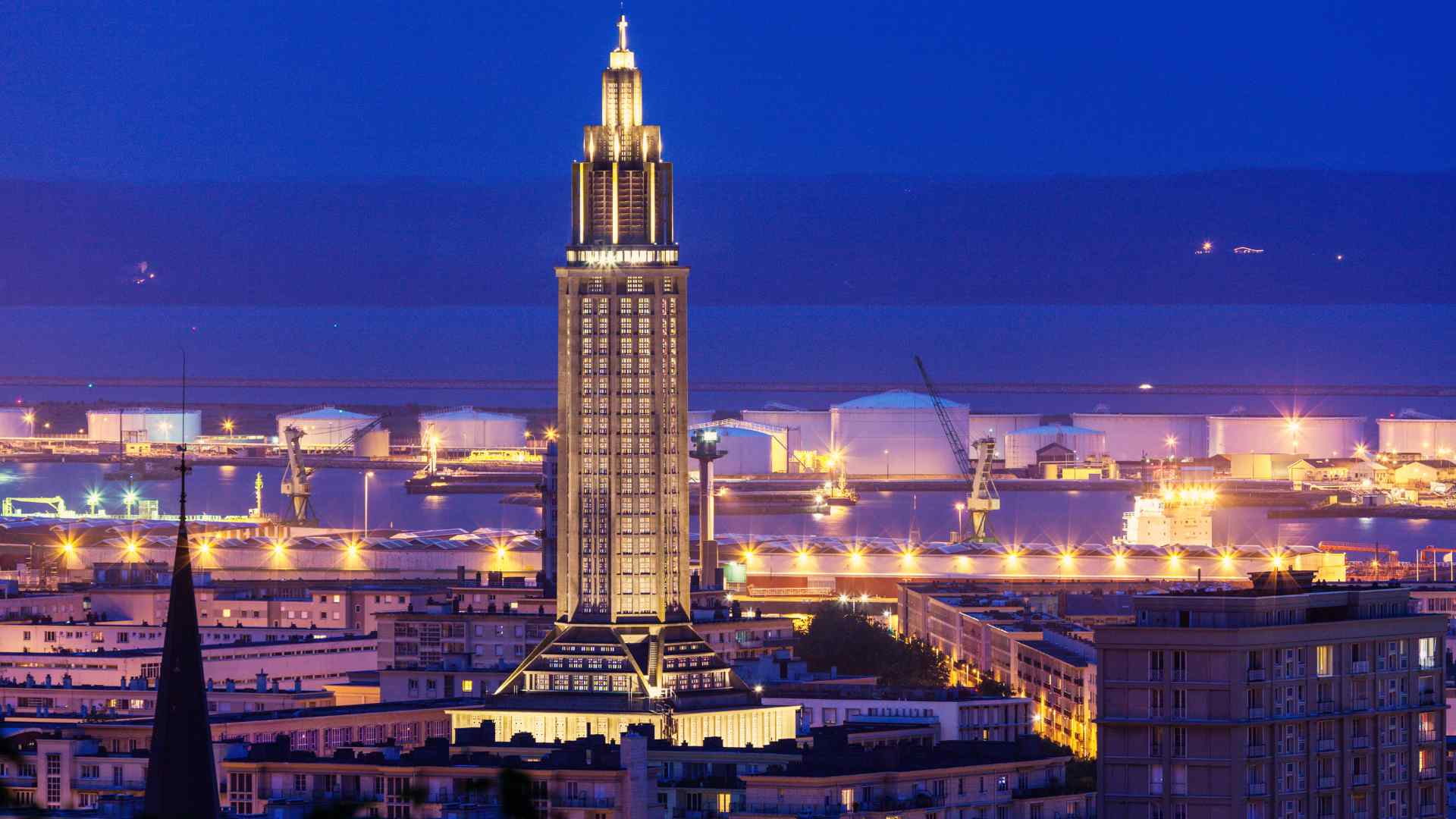 Illuminated Saint Joseph's Church above Le Havre port at night