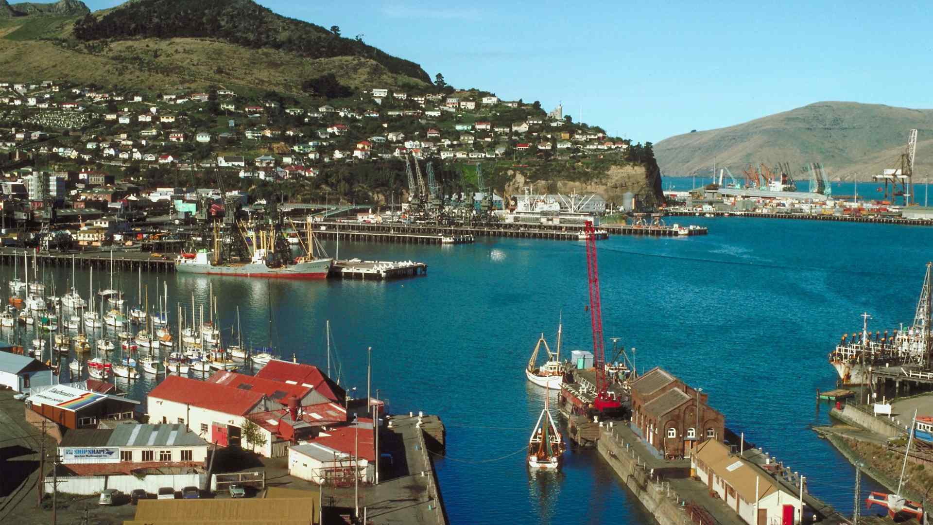Boats moored in Lyttelton Harbour beneath volcanic hills