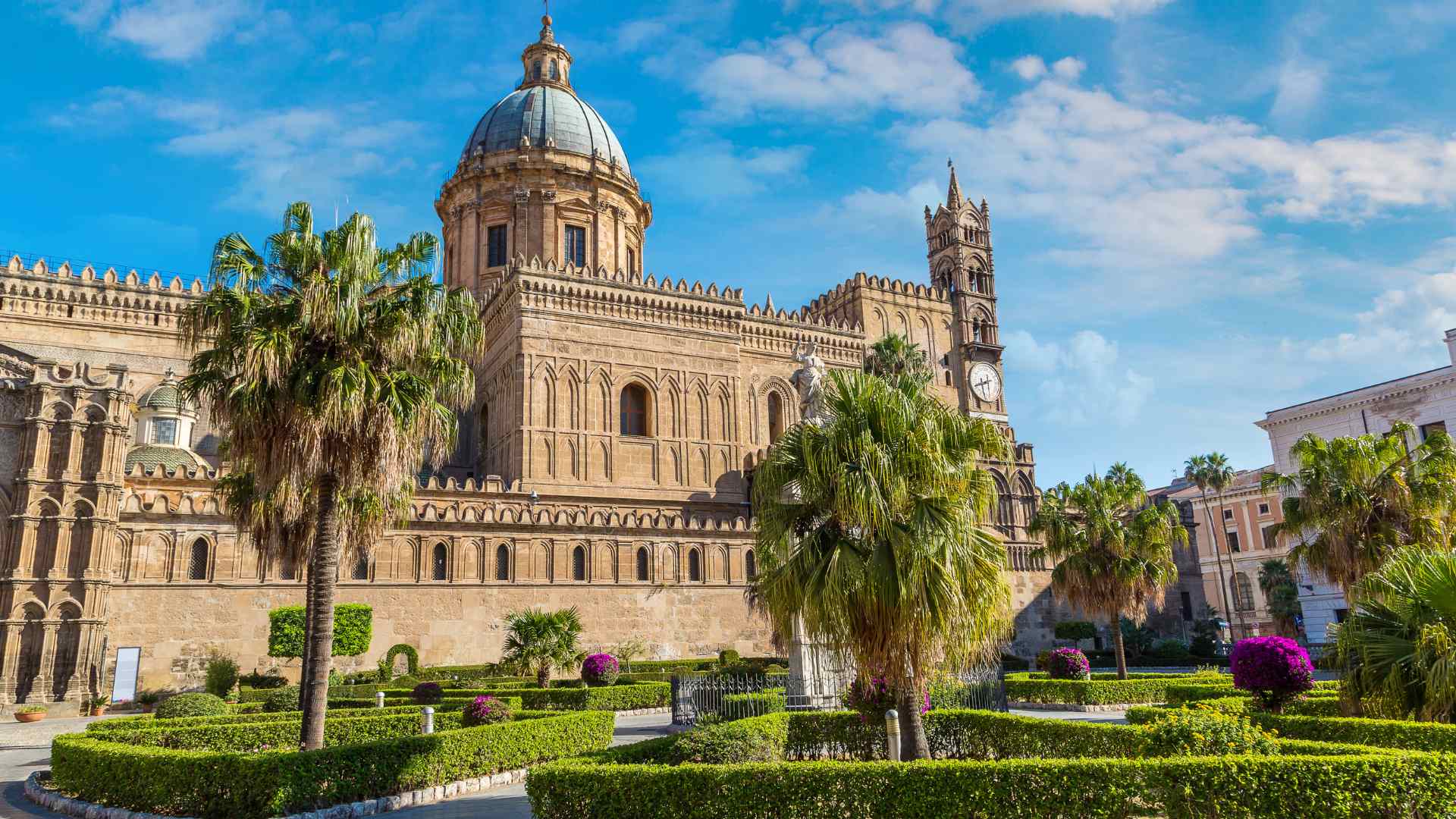 Palermo Cathedral framed by palm trees and gardens