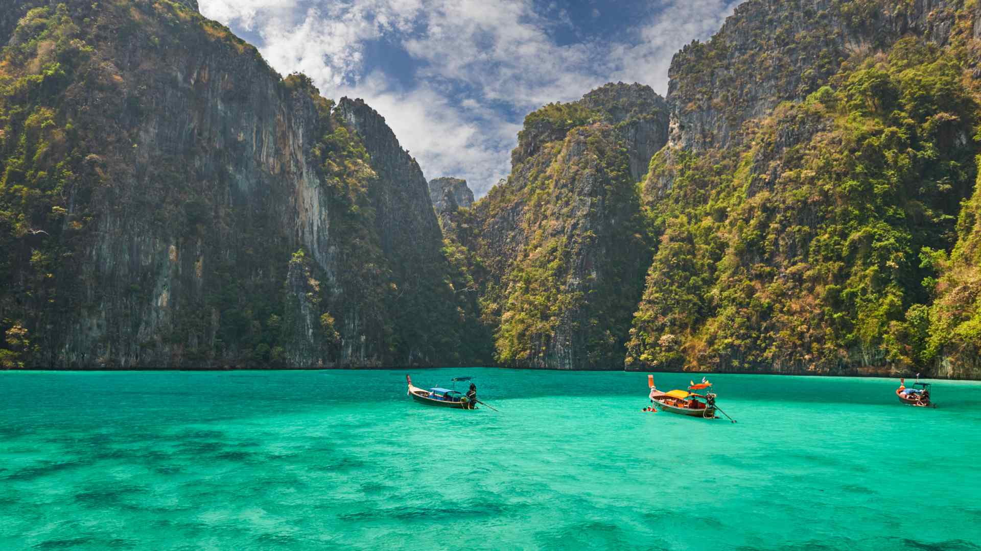 Long-tail boats in a turquoise cove near Phuket